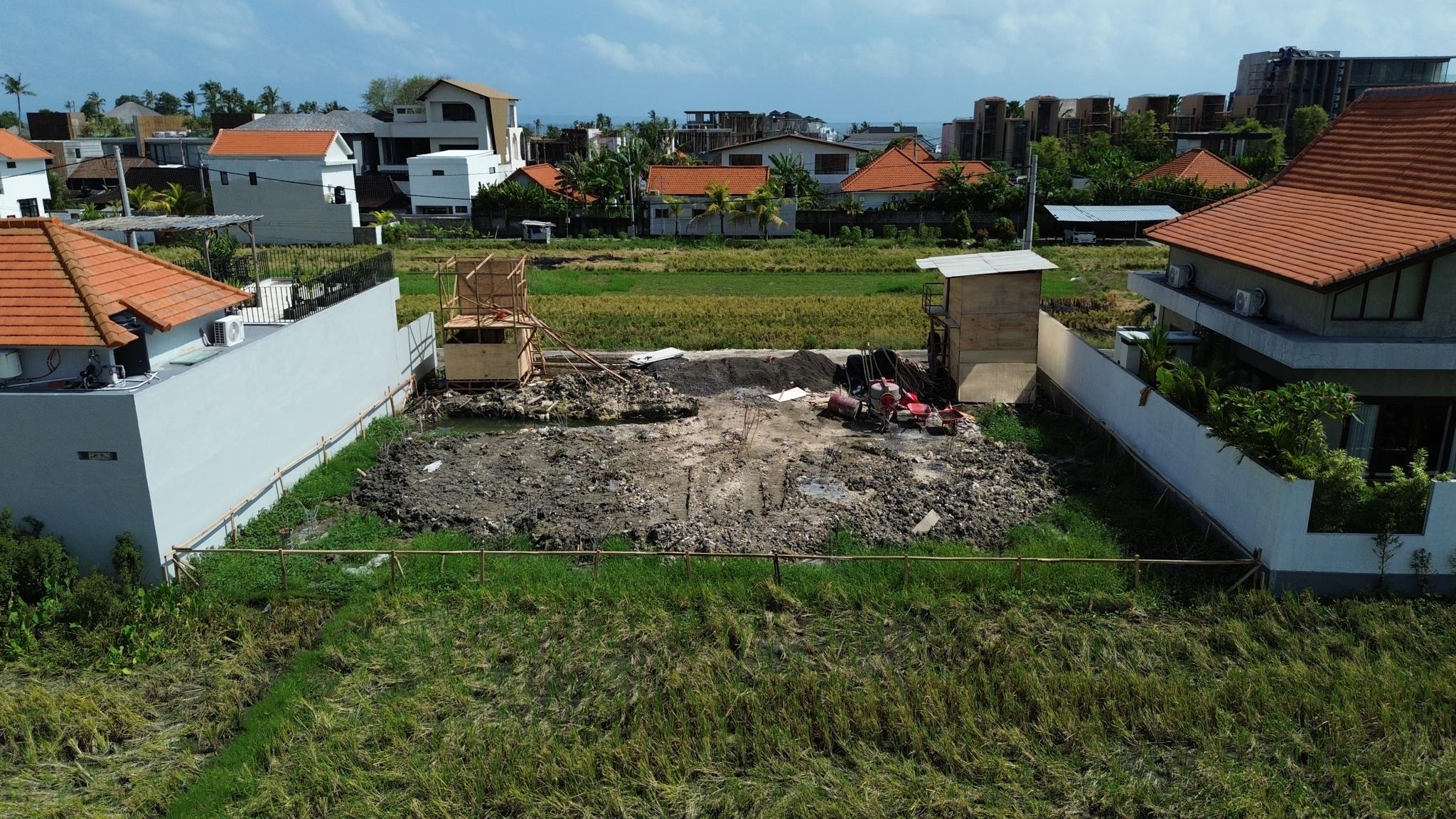 Chantier de construction de villa a Bali avec ouvriers et structure beton