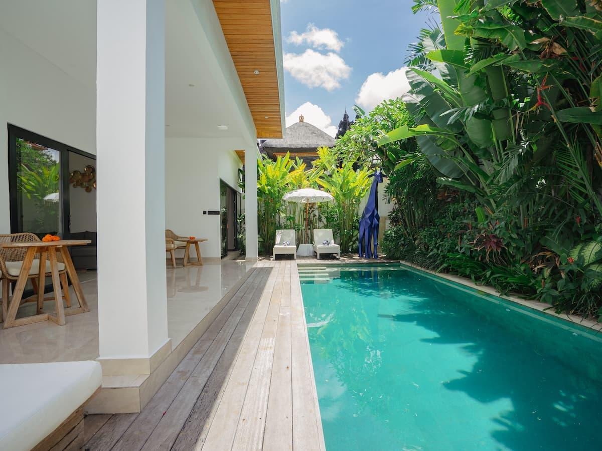 Intérieur de villa balinaise moderne avec salon ouvert et terrasse piscine