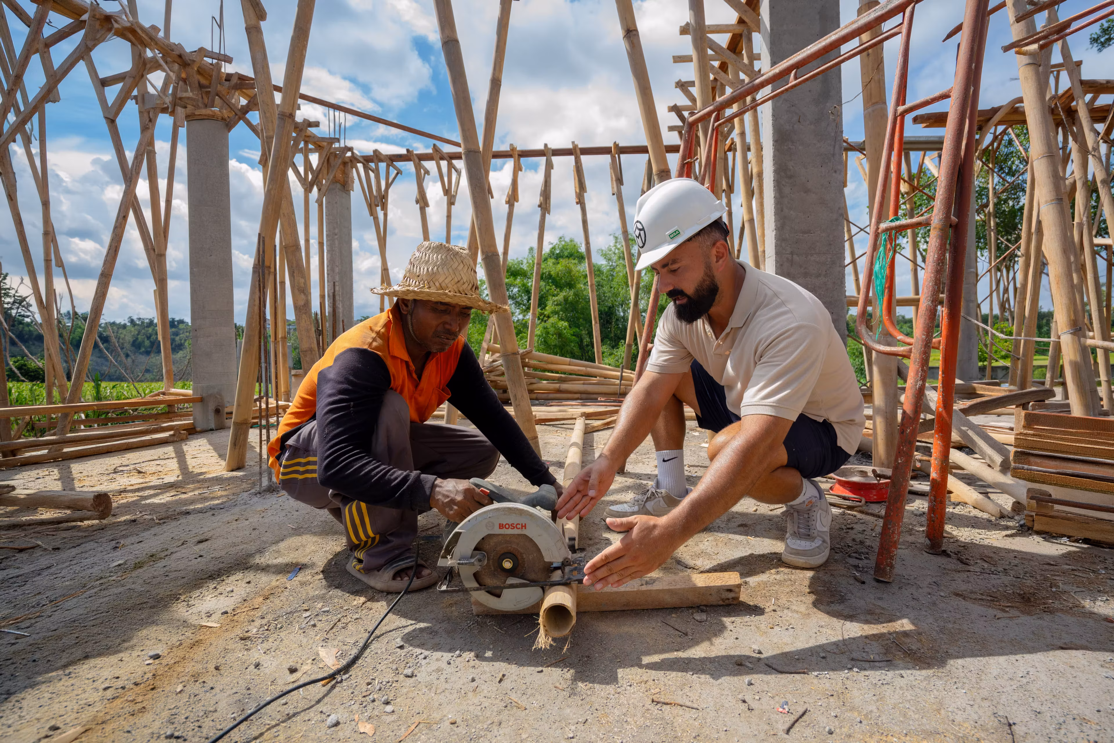 Chantier de construction de villa a Bali avec ouvriers et structure beton